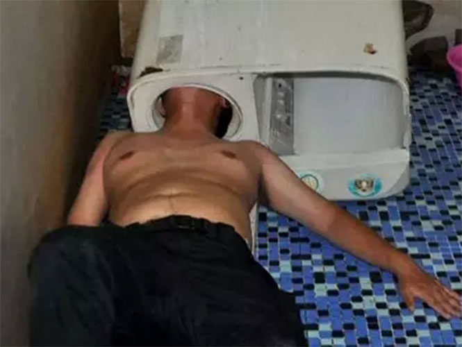 Intenta reparar la lavadora y se le atora la cabeza