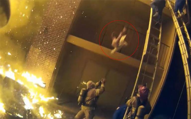 (VIDEO) Heroica labor de una bombero al cachar a una niña de un edificio en llamas