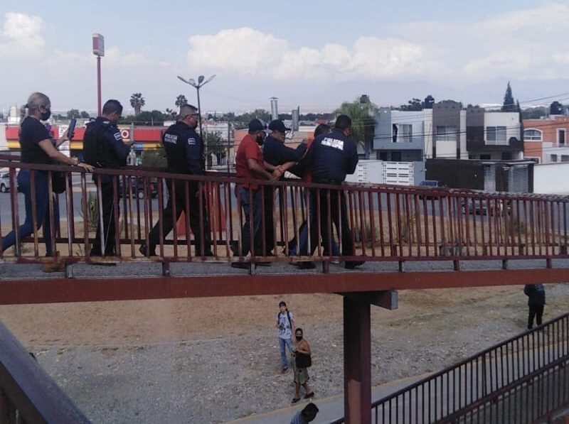 Policía y bombero rescatan a persona que <br>intentó lanzarse de puente peatonal